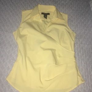 Sleeveless yellow blouse.
